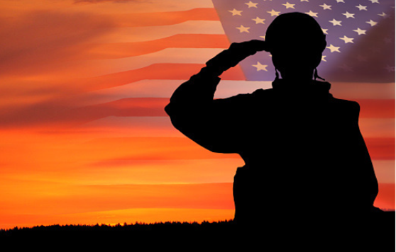 A silhouette of a soldier with a sunset in the background.