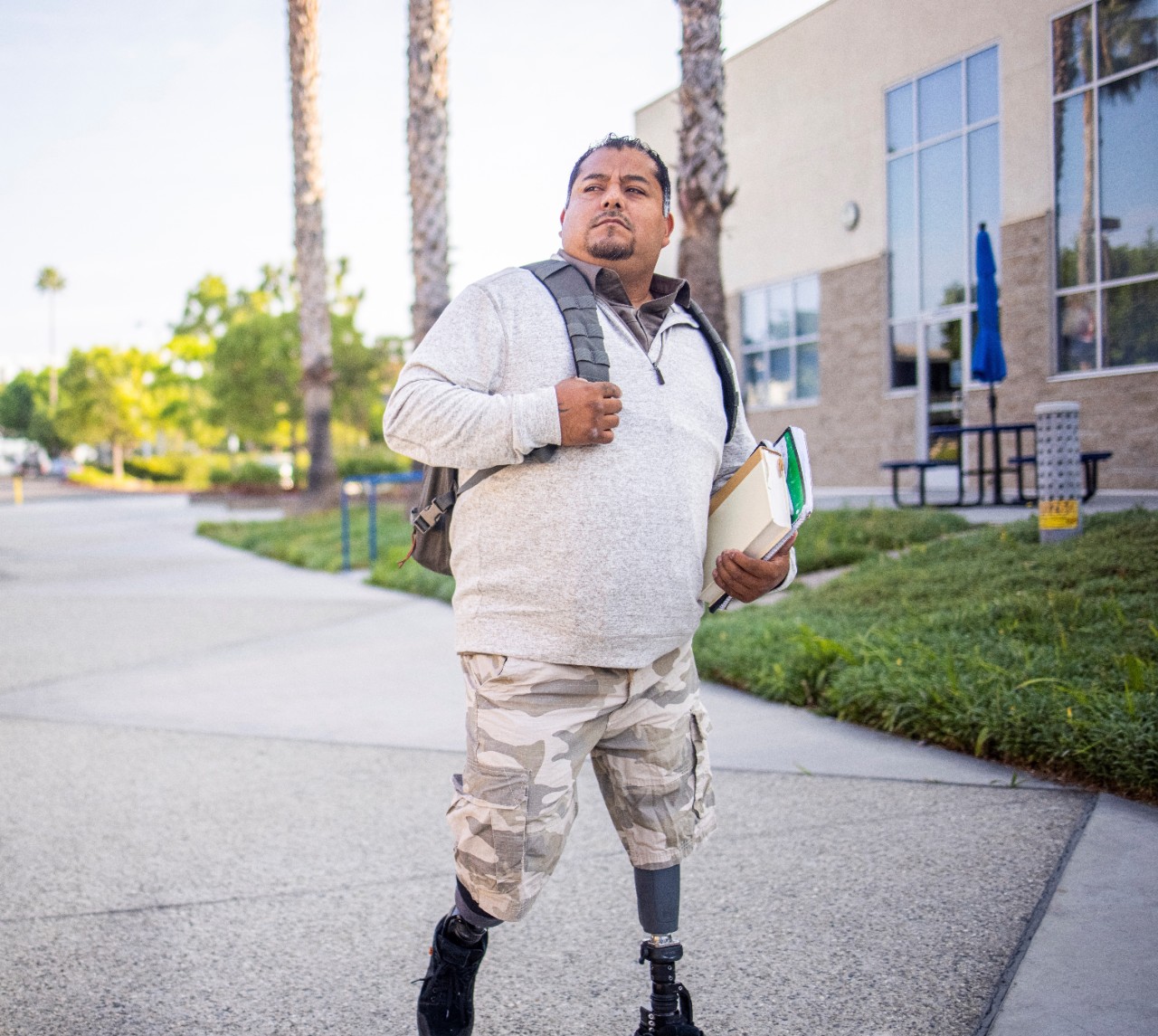 1273396305 A young Hispanic American Veteran college student going to class. He is a double amputee.