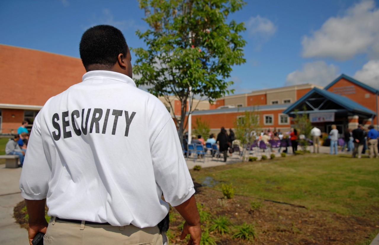 157197931 Security guard at a public junior high school -- students OOF in background