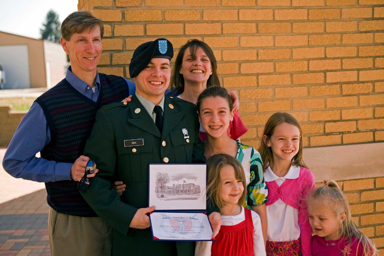 100318-A-3843C-010 Pvt. 1st Class Scott Wayne proudly holds his newly earned high school diploma with smiling family members at the Patriot Academy’s first graduating class’ graduation ceremony at the Muscatatuck Urban Training Center in Butlerville, Ind., March 18. Scott didn’t have enough credits to graduate with his high school class. He decided to join the Patriot Academy to earn his diploma and serve his country. The Patriot Academy is the U.S. military’s first ever accredited high school.