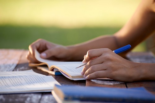 Young people and education, woman studying for university test Young women and education, close up of hands of girl studying for college exam in park. Side view, copy space