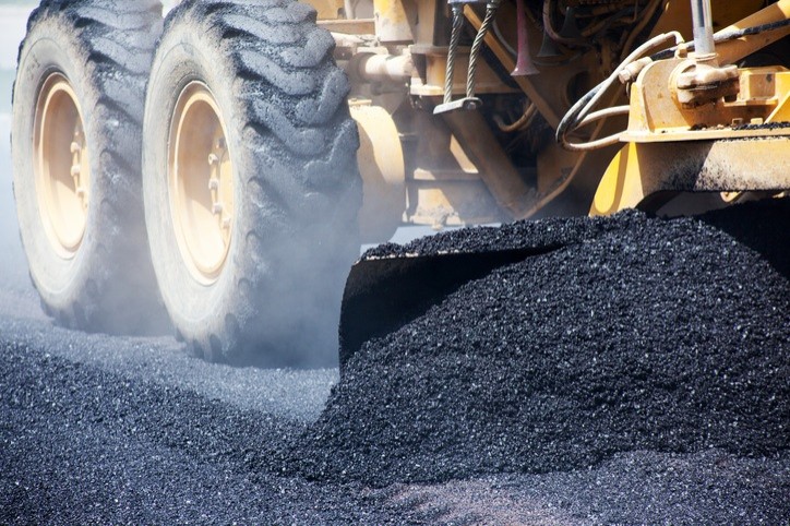 507071724 industrial pavement truck laying fresh asphalt on construction site