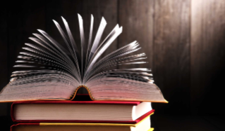 stack of books with a book flipped open on top