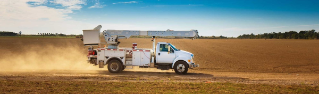 Utility truck driving on dirt road